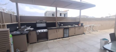 White aluminum pergola over an outdoor kitchen with a barbecue and bench tops